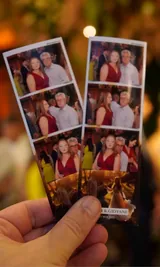 Tirinhas de fotos impressas pelo totem da Fotopop, na mão de um convidado numa festa