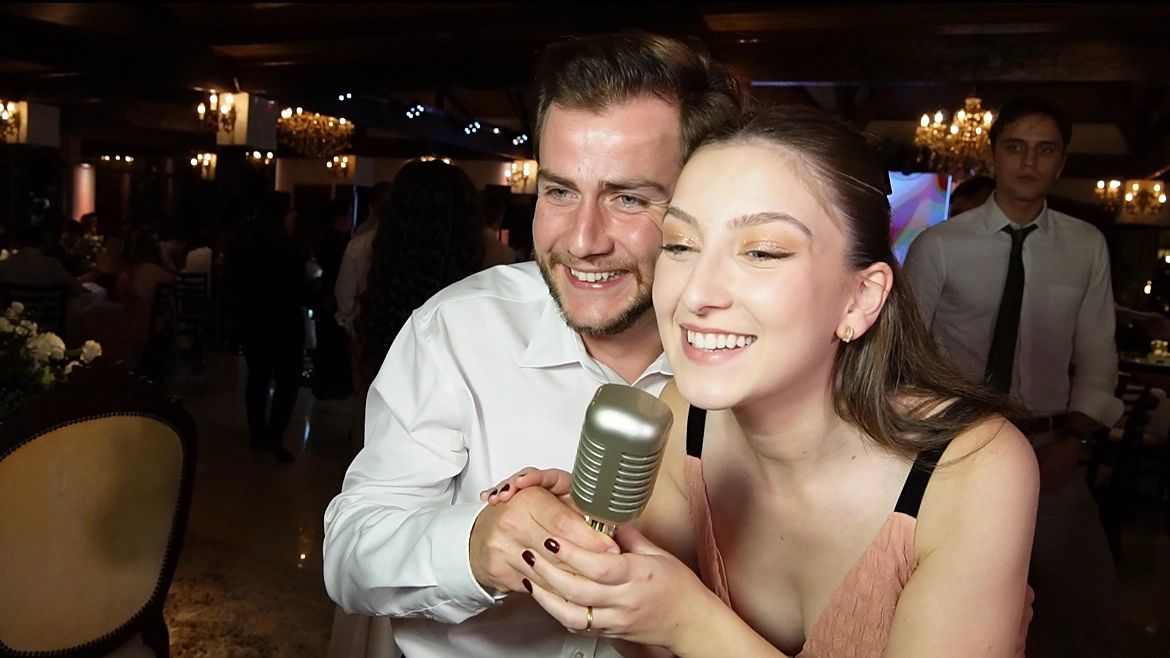 Foto de um casal de convidados com o microfone